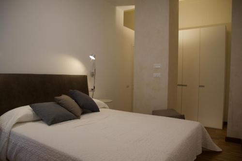a bedroom with a large white bed with blue pillows at B&B Mare di Fuori in Stintino