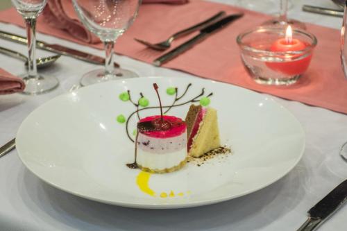 a white plate with a piece of cake on a table at Okwin Resort in Kandy