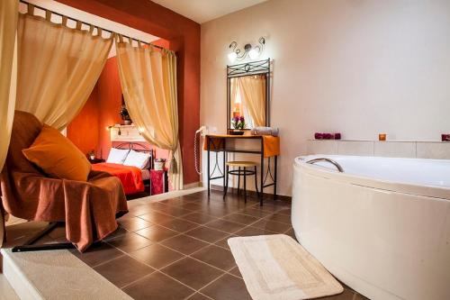 a bathroom with a bath tub and a bedroom at Estate Kares in Tílisos