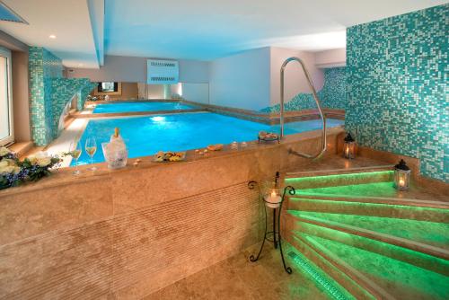 a large swimming pool in a hotel room with a pool at Guesia Village Hotel e Spa in Foligno