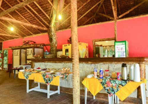 a room with two tables with yellow table cloth at Praia da Crena in Abraão