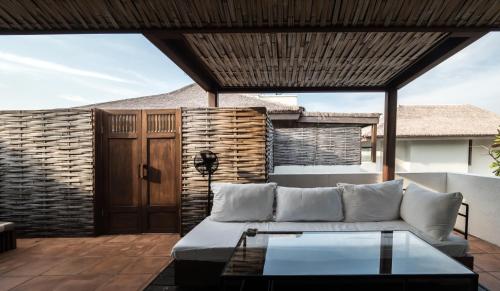 a living room with a couch on a patio at Putahracsa Hua Hin in Hua Hin