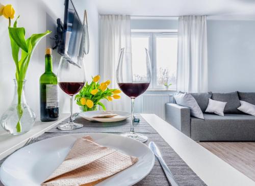 a living room with a table with two glasses of wine at Apartamenty Novomiejska 17 in Lublin