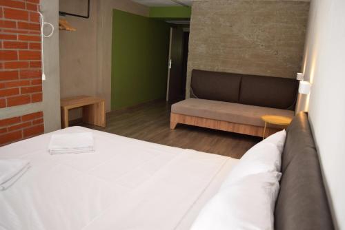 a bedroom with a bed and a couch in a room at Urban Donkey in Thessaloniki