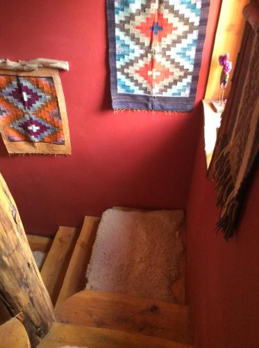 a room with a staircase with quilts on the wall at Lodge Tikilen Caviahue in Caviahue