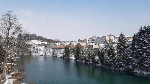 a river in a city with snow on the ground at Apartment Sobe Ravbar in Novo Mesto