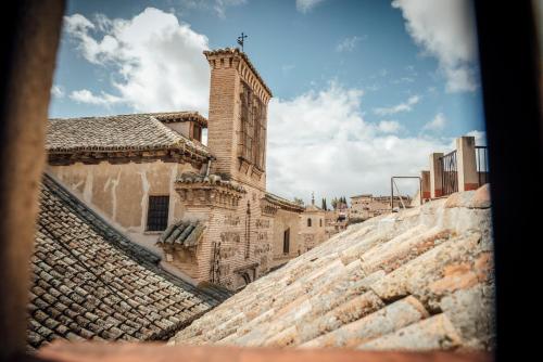 a building with a tower on top of a wall at Hotel Santa Isabel in Toledo