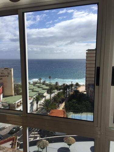 una ventana de hotel con vistas al océano en Cozy Apartment, en Candelaria