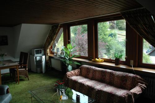 a living room with a couch and some windows at Gasthof Holländer Eck in Lennestadt