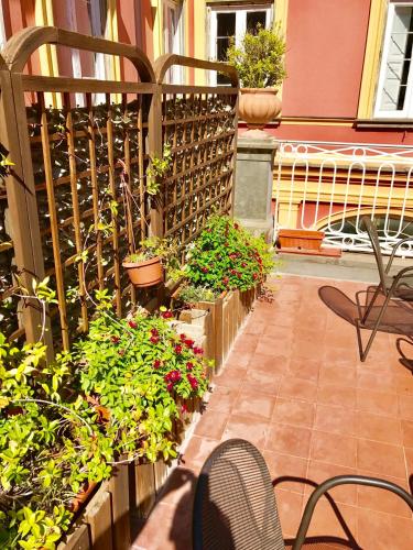 a patio with plants and chairs and a fence at The Secret Garden Relais in Piano di Sorrento