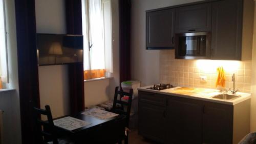 a kitchen with black cabinets and a sink and two chairs at Casa Maria e Casa Cristina in Orvieto