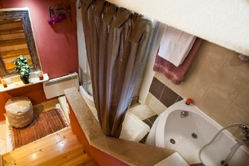 a bathroom with a tub and a toilet and a shower at Estate Kares in Tílisos