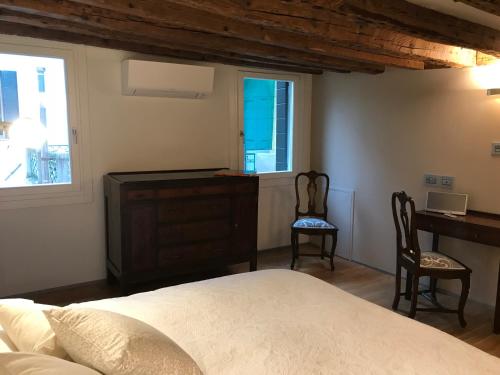 a bedroom with a bed and a desk and two chairs at 27@SMarco in Venice