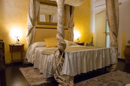 a bedroom with a canopy bed and a mirror at Agriturismo Campofiorito in Monsummano Terme