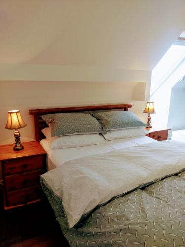 a bedroom with a bed and two lamps on a night stand at The Hollies in Adare