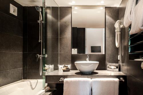 亞維儂的住宿－克魯爾特聖路易斯阿維農酒店，浴室配有盥洗盆和浴缸。