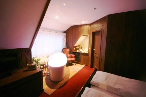 a bedroom with a bed and a room with a lamp at Hotel Wellness Goldenes Fass Meißen in Meißen