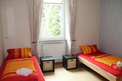 Pension Röhrig في Hirzenach: سريرين في غرفة مع نافذة