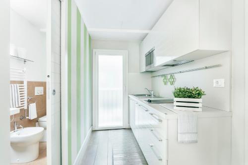 un bagno bianco con lavandino e WC di Petronio Residence a Bologna