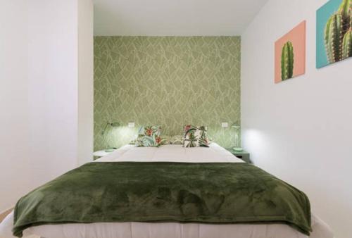 ラスパルマス・デ・グランカナリアにあるStylish apartment in Canteras beachのベッドルーム1室(大型ベッド1台、緑の毛布付)