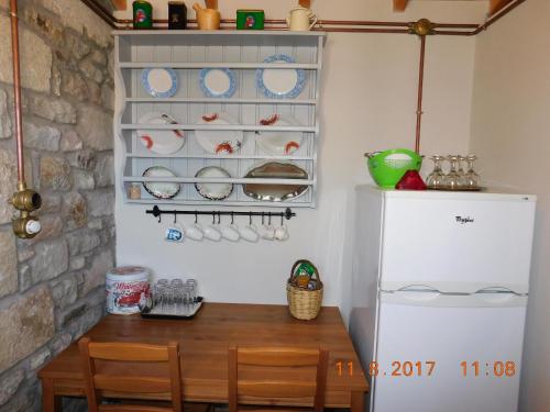 a kitchen with a table and a refrigerator at Stone cottage for couple in Thános