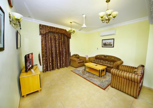 a living room with two couches and a table at Muscat International Hotel in Muscat