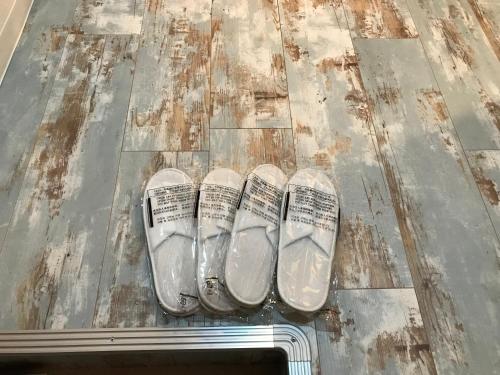 two pairs of shoes sitting on a wooden floor at Guest house AKASAKA in Fukuoka