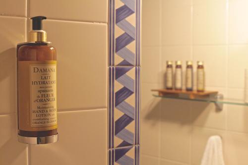 a bottle of soap sitting on a shelf in a bathroom at Monte da Xica - Somente Adultos in Zambujeira do Mar