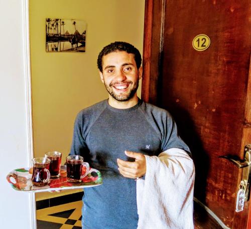 a man is holding a tray of drinks at The Pyramid Lofts in Cairo