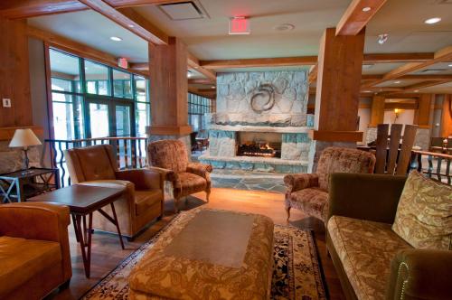 a living room with couches and a fireplace at First Tracks Lodge in Whistler