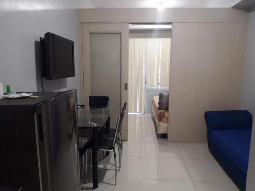 un soggiorno con tavolo da pranzo e televisione di Sea Residences - Rheiyn a Manila
