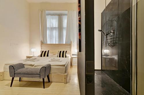 sypialnia z łóżkiem, krzesłem i oknem w obiekcie Historic Centre Apartments VI w Pradze