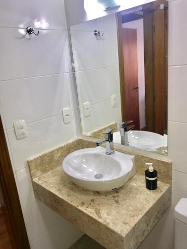 a bathroom with a sink and a mirror at Apartamento no Centro de Gramado in Gramado