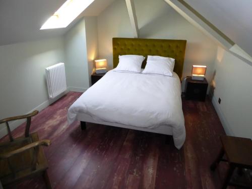 a bedroom with a bed with white sheets and two lamps at B&B A La Maison Blanche in Fécamp