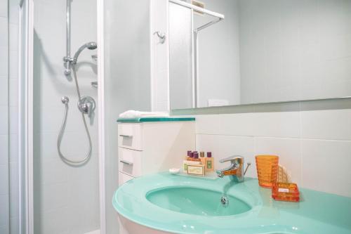 Un baño con un lavabo azul y una ducha. en Darsena Apartment, en Génova