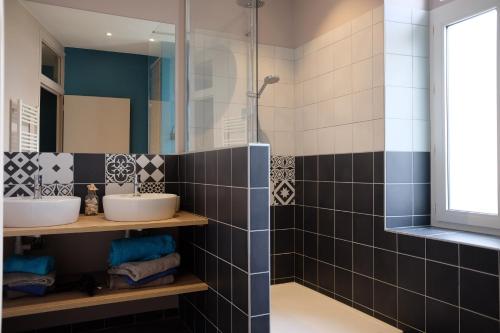 une salle de bain avec deux lavabos et une douche dans l'établissement Appartement Saint Malo-Rocabey, à Saint-Malo