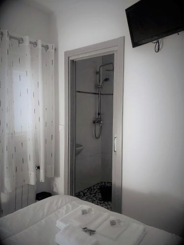 a bedroom with a white bed and a shower at Albergue Camiño Real in Sigüeiro
