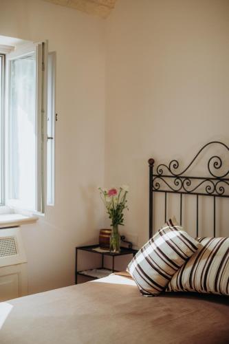 a bedroom with a bed with a pillow and a window at Masseria Ancella in Montalbano