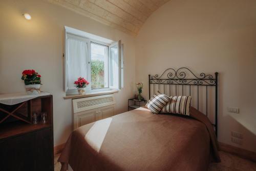 a bedroom with a large bed and a window at Masseria Ancella in Montalbano