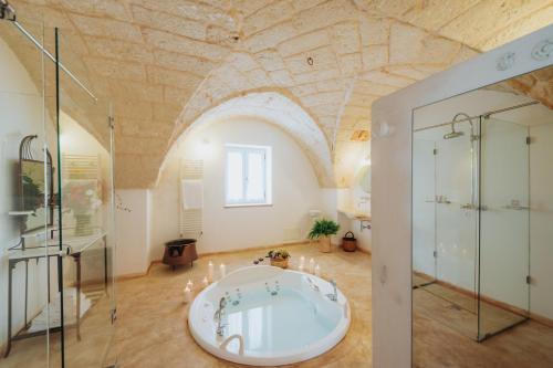 uma grande casa de banho com banheira num quarto com tecto em Masseria Ancella em Montalbano
