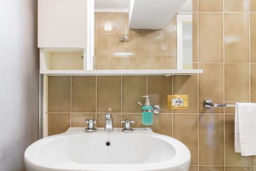 ein Badezimmer mit einem weißen Waschbecken und einem Spiegel in der Unterkunft Lake Panorama - byMyHomeinComo in Como