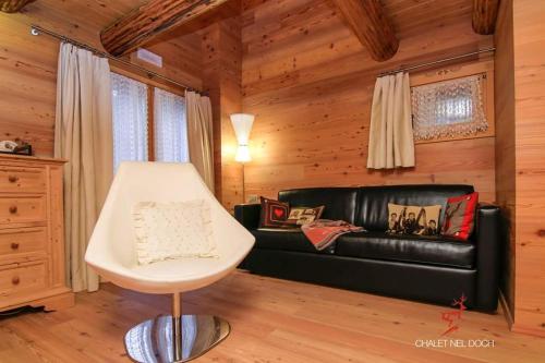 a living room with a black leather couch and a table at Chalet Nel Doch in Canale San Bovo