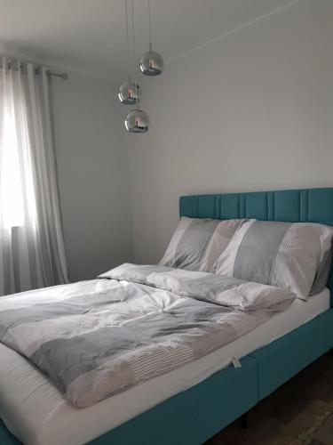 ポズナンにあるApartamenty Strzeleckaのベッドルーム1室(青いヘッドボード付)