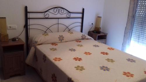 トレビエハにあるCasa Junto Al Marのベッドルーム1室(花柄のベッドカバー付)