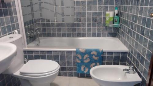 トレビエハにあるCasa Junto Al Marの青いタイル張りのバスルーム(トイレ、シンク付)