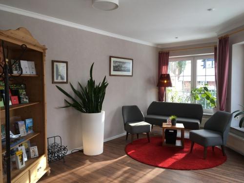 a living room with a couch and chairs and a plant at Flair Landhotel Strengliner Mühle in Pronstorf