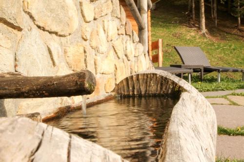 a water fountain in a stone wall at Chalet Nel Doch in Canale San Bovo