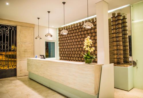 a lobby with a reception counter with a wall of wine barrels at Hotel Boutique Bovedas de Santa Clara By Accor in Cartagena de Indias