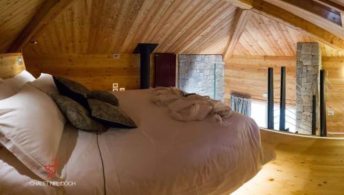 ein Schlafzimmer mit einem Bett in einem Blockhaus in der Unterkunft Chalet Nel Doch Villa Cheia in Canale San Bovo