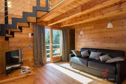 a living room with a couch and a staircase at Chalet Nel Doch in Canale San Bovo